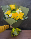 Buchet cu trandafiri galbeni înfloriți manual, lisianthus și verdeață naturală, ambalat elegant cu fundă din satin.