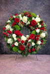 Coroană funerară premium cu trandafiri roșii, trandafiri albi și green trick, realizată manual pentru ceremonii funerare.